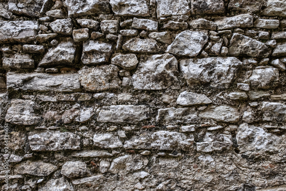 Stone wall background, dark grey limestone texture