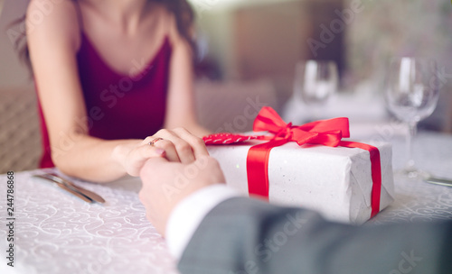 Valentine's Day concept. Happy couple in love with. A young loving couple celebrating Valentine's Day in the restaurant. Lovers give each other gifts. Romance restaurant for Valentine's Day- concept.