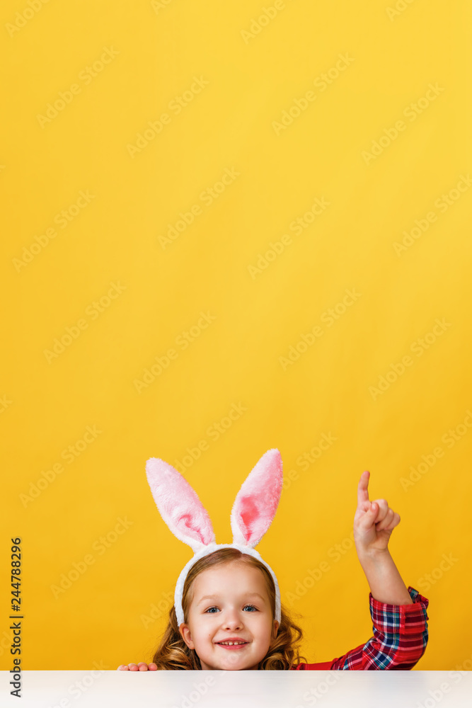 Cute little child girl with bunny ears at home is hunting for Easter eggs.