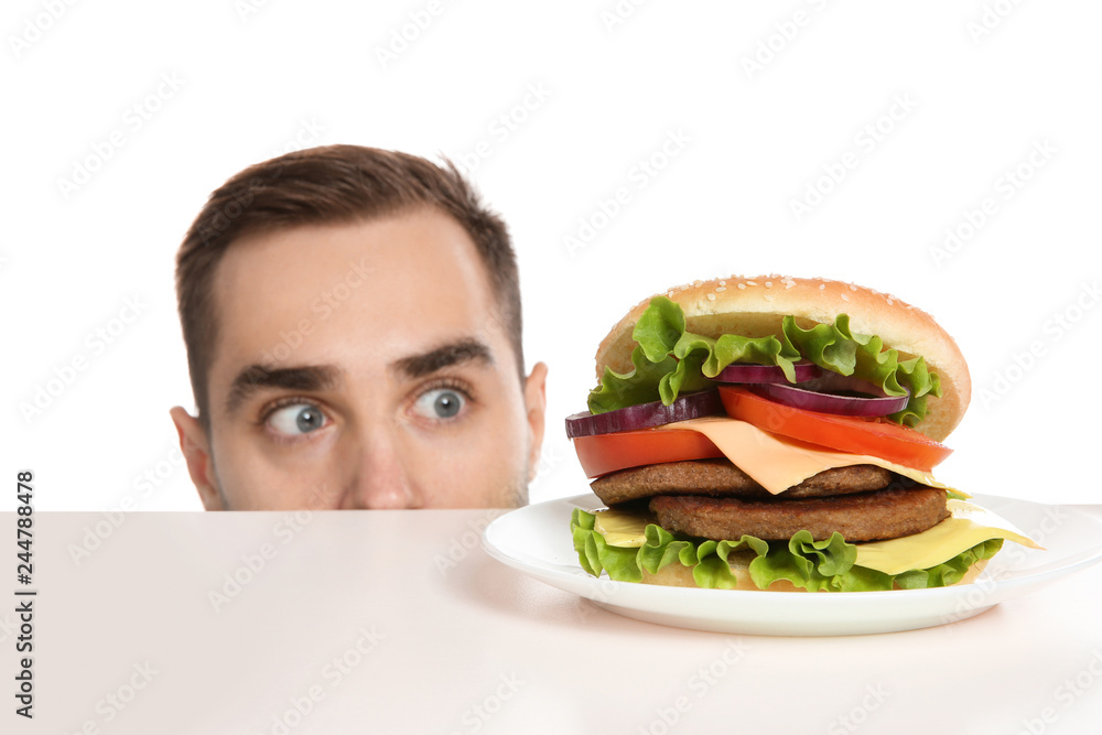 Young man with tasty burger on white background Young man with tasty burger on white background