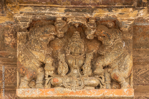 Belur, Karnataka, India - November 2, 2013: Chennakeshava Temple building. Brown stone statue of Devi Lakshmi in classic pose with two showering elephants in niche on wall of temple. photo