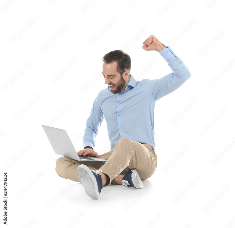 Emotional young man with laptop celebrating victory on white background