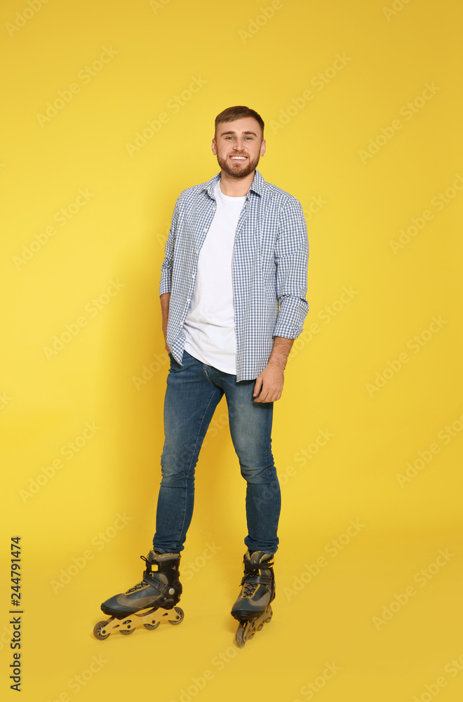 Full length portrait of young man with inline roller skates on color background Full length portrait of young man with inline roller skates on color background
