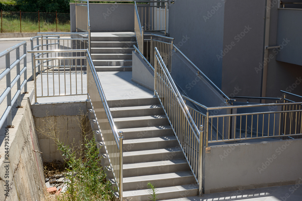 Outdoor stairwell with many shining steel railings.