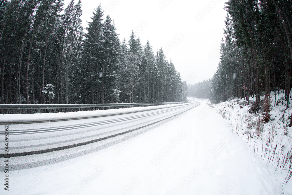 Obraz premium Beautiful landscape with conifer forest and road on snowy winter day