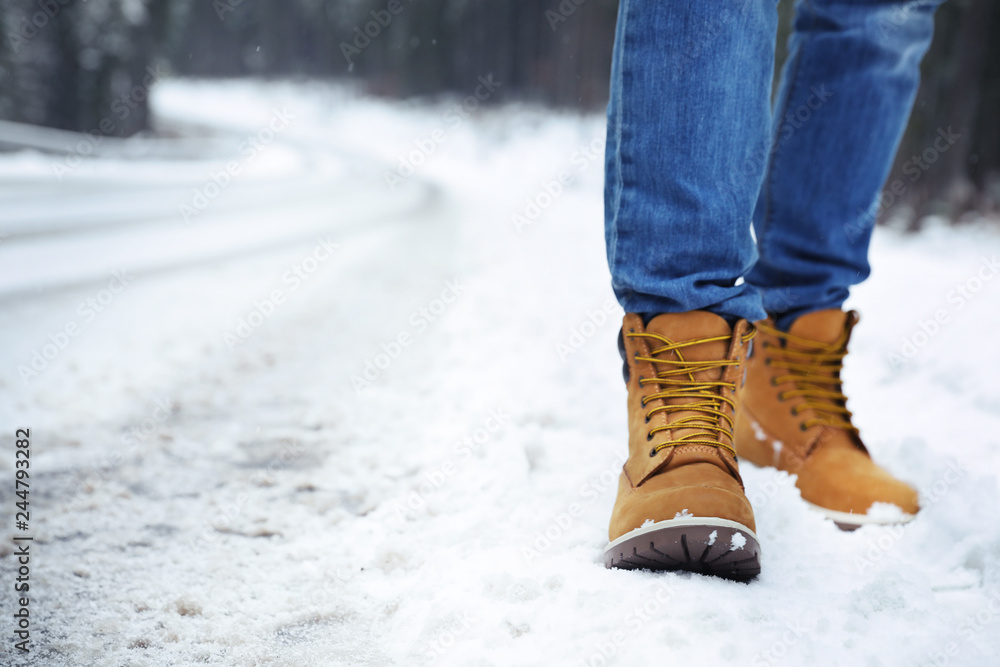 Man walking outdoors on snowy winter day. Space for text Man walking outdoors on snowy winter day. Space for text
