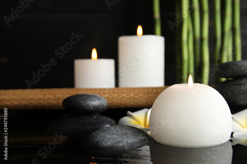 Spa composition with burning candle in water, space for text