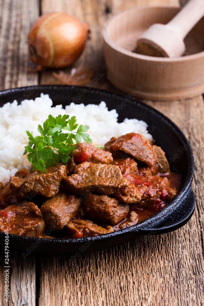 Beef stew served with white rice in cast iron skillet Beef stew served with white rice in cast iron skillet