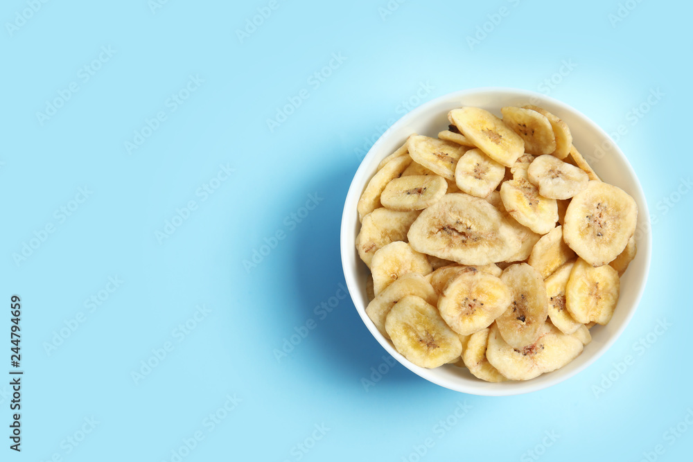 Bowl with banana slices on color background, top view with space for text. Dried fruit as healthy snack Bowl with banana slices on color background, top view with space for text. Dried fruit as healthy snack