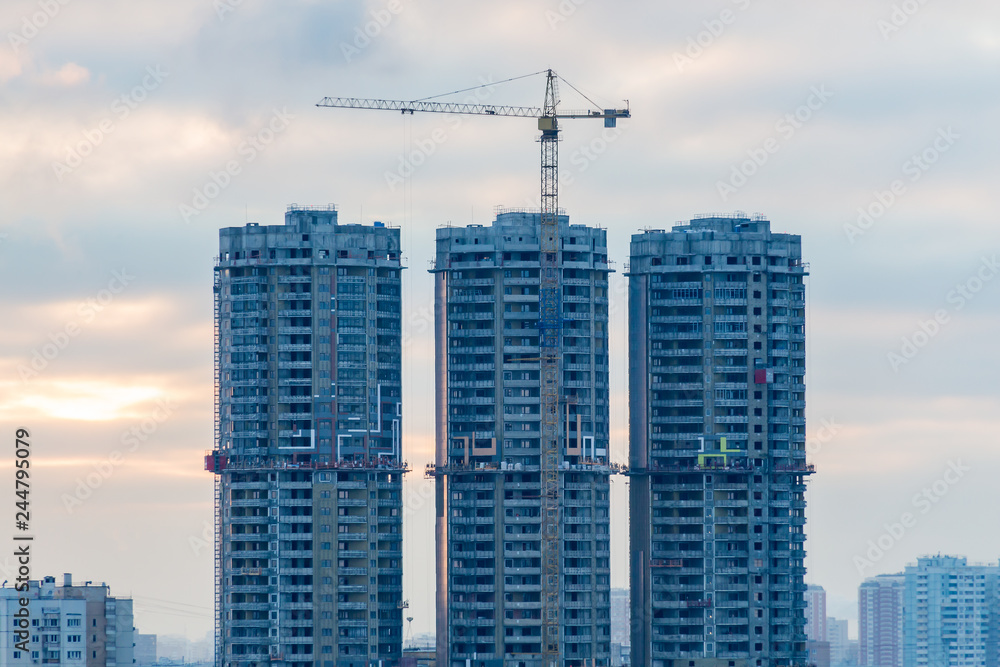 Construction of high-rise residential buildings in the big city. Winter cityscape at sunset. Moscow, Russia