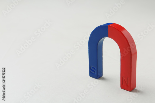 Red and blue horseshoe magnet on white background. Space for text