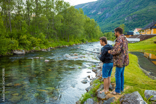 Father and son are fishermans fly fishing in river near Rodal town, Norway photo