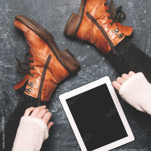 Female legs shod in Hiking boots and tablet pc. Mockup for text or apps photo