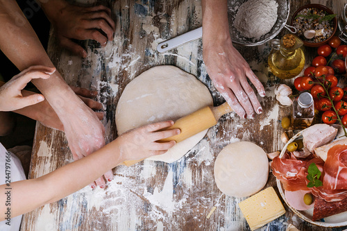 Wallpaper Mural Woman with child preparing dough for homemade pizza. Light toning. Top view Torontodigital.ca