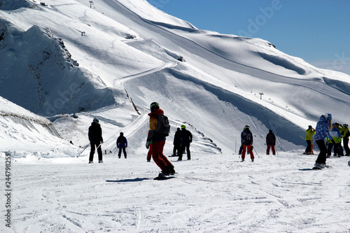 Skiers and snowboarders riding on a ski slope in Sochi mountain resort snowy winter photo