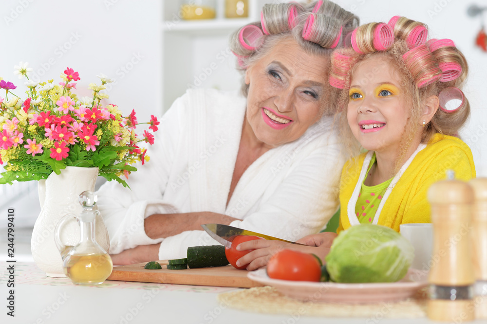Senior woman and granddaughter cooking at kitchen Senior woman and granddaughter cooking at kitchen