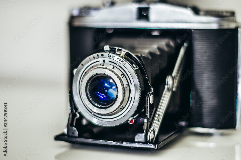 Old retro camera with blue lens and bellows