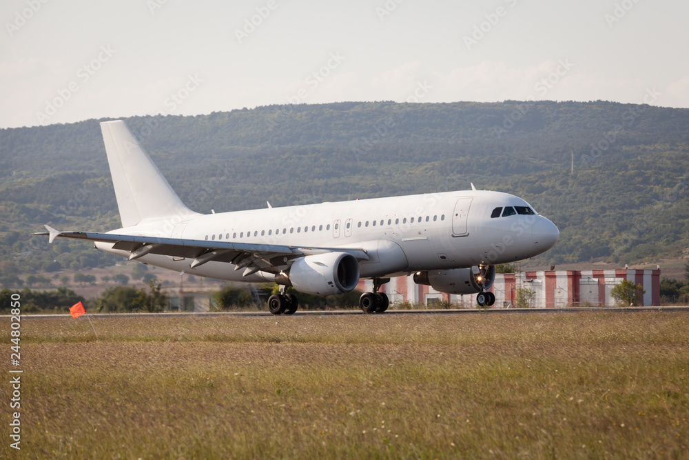 White passenger plane is landing on the airport. White passenger plane is landing on the airport.