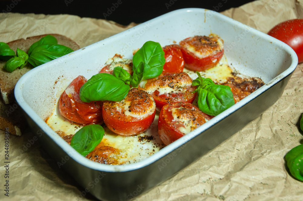 Closeup detail look on fresh vegetarian sliced and salted tomatoes ready to bake covered with cheese and fresh organic basil