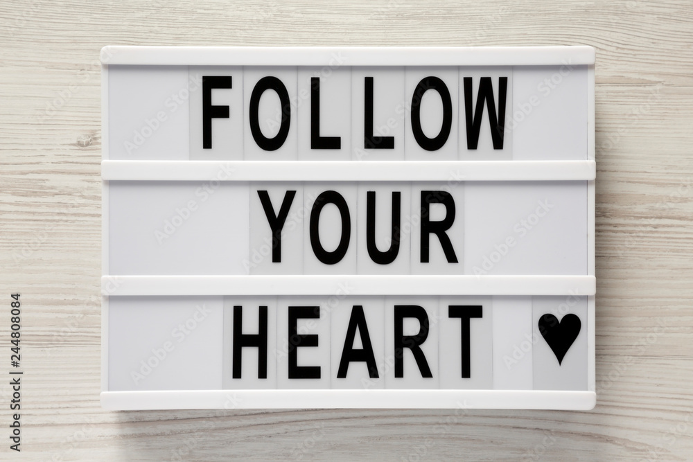 Lightbox with text 'Follow your heart' on a white wooden background, top view. Flat lay, overhead. Valentine's Day 14 February. Lightbox with text 'Follow your heart' on a white wooden background, top view. Flat lay, overhead. Valentine's Day 14 February.