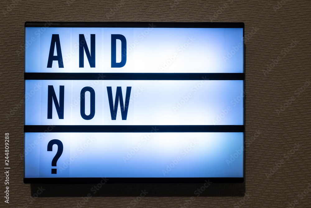 Message And Now? on illuminated board. Question about decision concept with text. Message And Now? on illuminated board. Question about decision concept with text.
