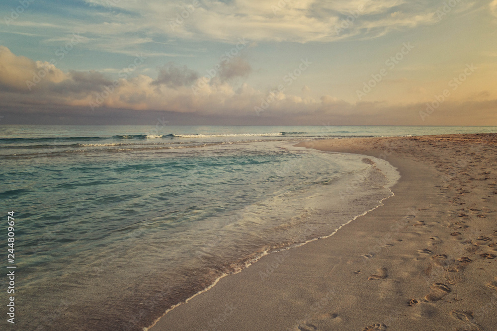 Morning surf, clouds and footprints at the beach of Varadero, Cuba
