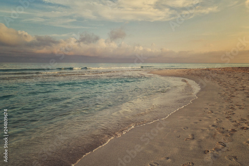 Fototapeta Naklejka Na Ścianę i Meble -  Morning surf, clouds and footprints at the beach of Varadero, Cuba
