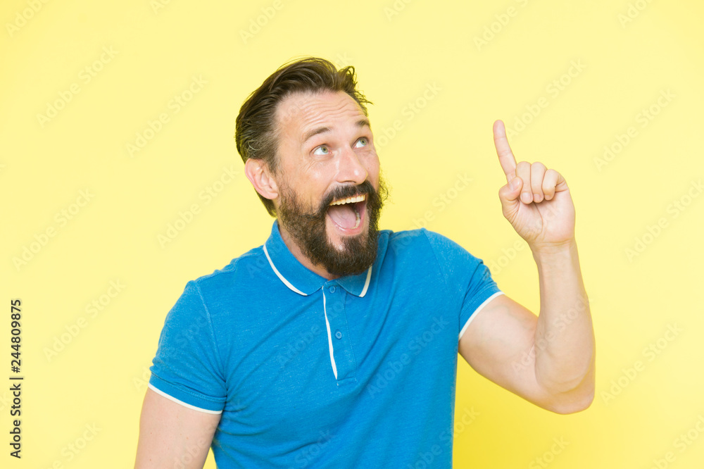 Fresh idea concept. Handsome smiling mature man keeping finger raised and looking upwards while standing against yellow background. Man bearded cheerful fresh idea. Birth of ideas. Idea gesture Fresh idea concept. Handsome smiling mature man keeping finger raised and looking upwards while standing against yellow background. Man bearded cheerful fresh idea. Birth of ideas. Idea gesture