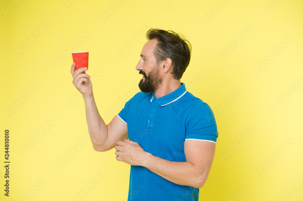 Relaxing coffee break. Drink it on the go. Man bearded prefer coffee take away. Eco lifestyle and recycling. Recyclable coffee cup. Hipster mature man hold paper coffee cup stand yellow background Relaxing coffee break. Drink it on the go. Man bearded prefer coffee take away. Eco lifestyle and recycling. Recyclable coffee cup. Hipster mature man hold paper coffee cup stand yellow background
