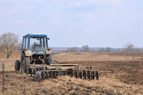 Fotografie Old tractor with rusty harrow