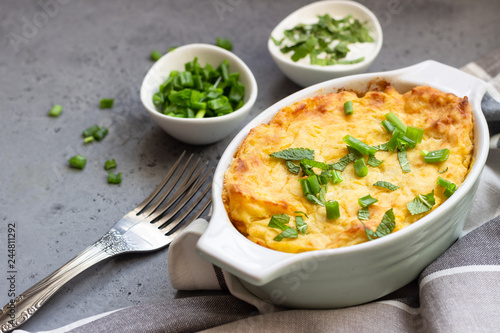 Potatoes casserole with cheese and green onion served with sour cream and mint. Vegetarian food. Copy space.