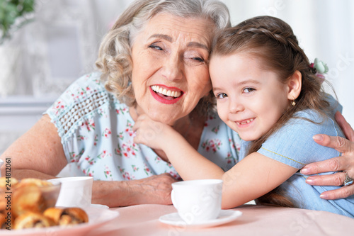 Old woman with a young girl drinking tea