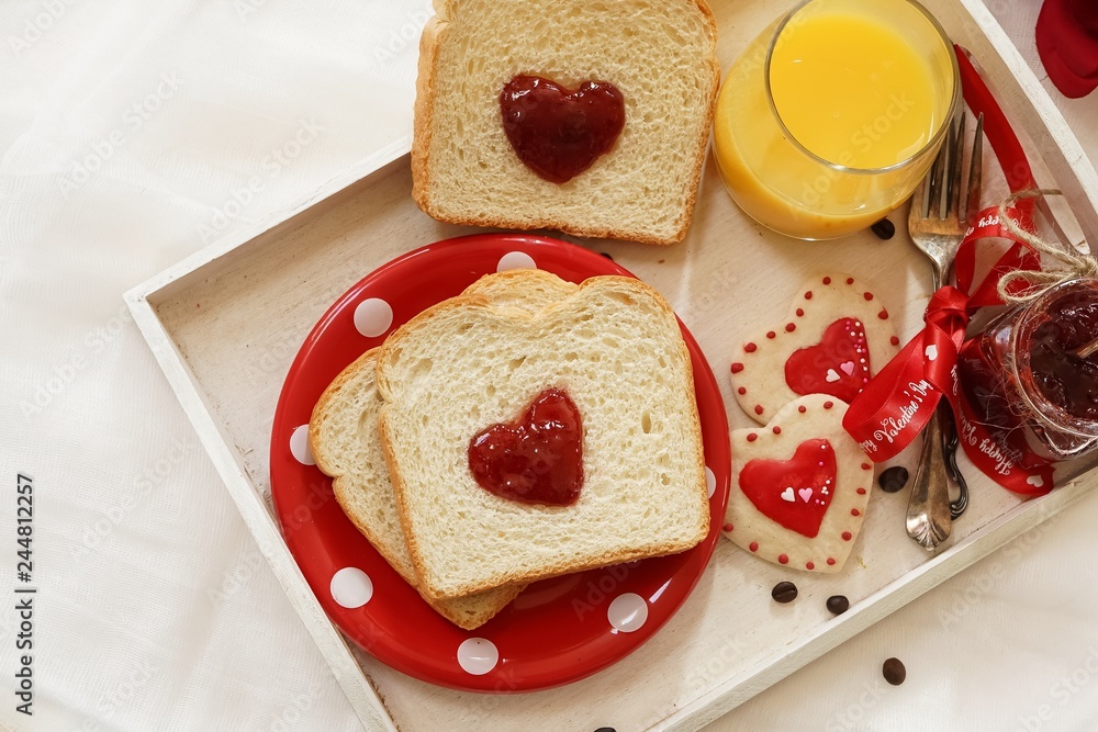 Valentines day breakfast in bed sandwich with red jam hearts coffee on a white tray Valentines day breakfast in bed sandwich with red jam hearts coffee on a white tray