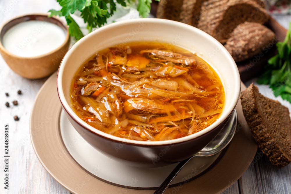Traditional Russian sauerkraut soup Shchi in bowl on rustic wooden background. Selective focus. Traditional Russian sauerkraut soup Shchi in bowl on rustic wooden background. Selective focus.