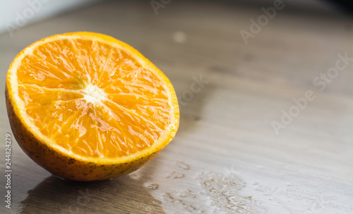 orange on wooden table with water on the bottom 
