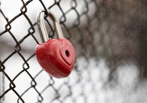 background. a red lock in the shape of a heart is hanging on the fence. Valentine s day holiday.