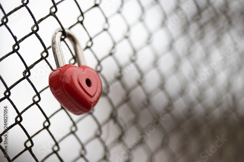 background. a red lock in the shape of a heart is hanging on the fence. Valentine s day holiday.