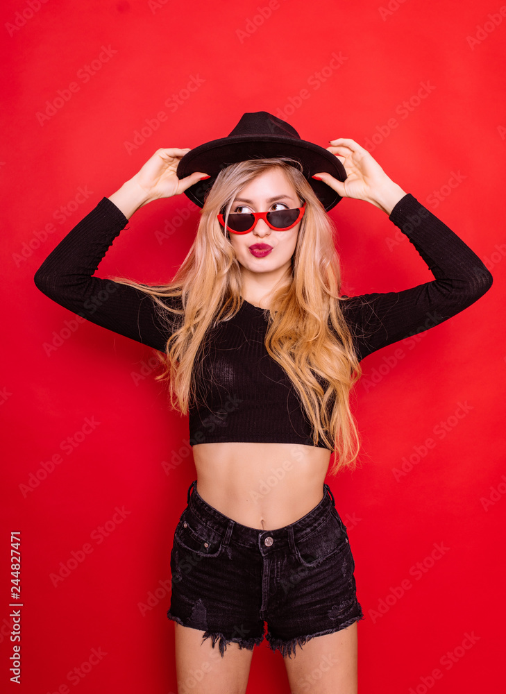Fashion beautiful young woman in sunglasses isolated on red background Fashion beautiful young woman in sunglasses isolated on red background