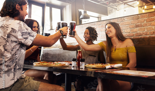 Принти на полотні Multi-ethnic group of friends toasting soft drinks at cafe