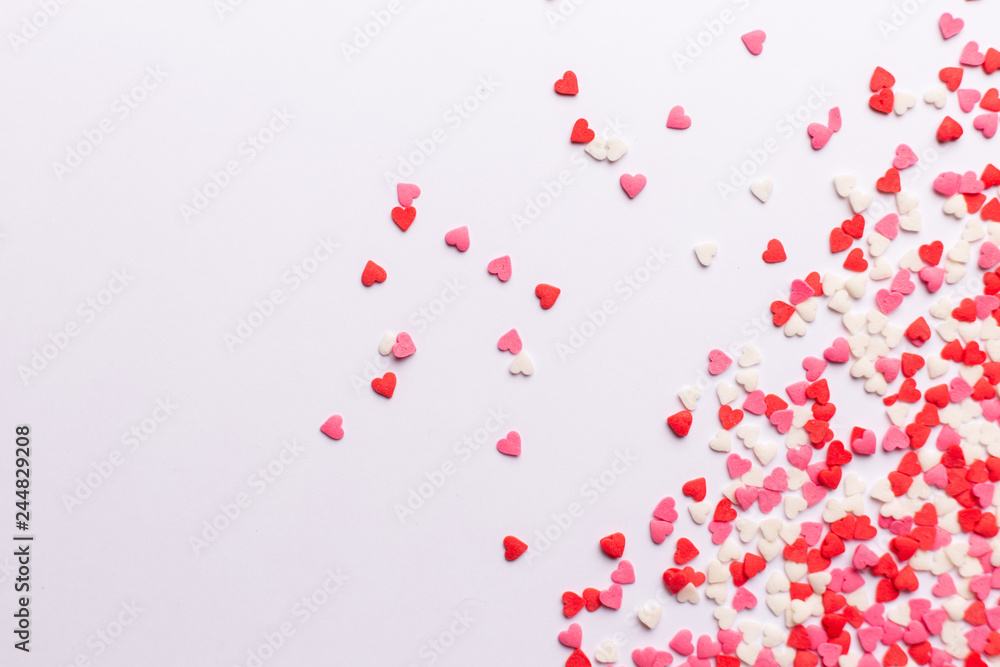 Red, pink and white heart shaped sweets scattered on white background. space for text. flat lay. Red, pink and white heart shaped sweets scattered on white background. space for text. flat lay.