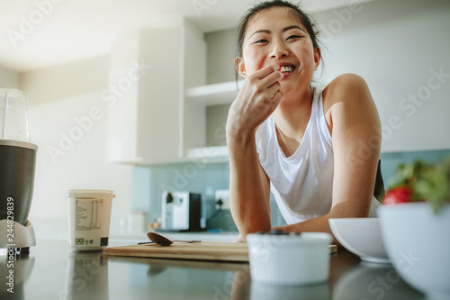 Fotografie Healthy woman standing in the kitchen and smiling
