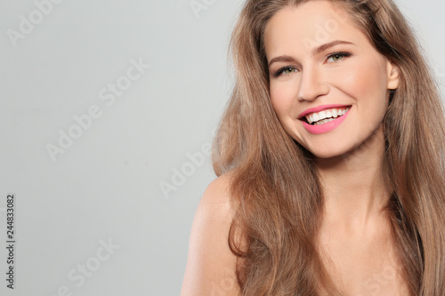 Young woman wearing beautiful lipstick on gray background. Space for text