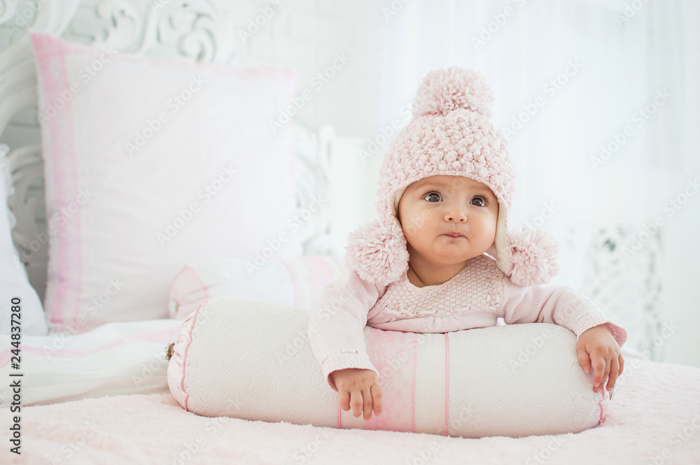 Portrait of a baby in a hat on the bed in his room. The concept of a happy child. Diapers. Portrait of a baby in a hat on the bed in his room. The concept of a happy child. Diapers.