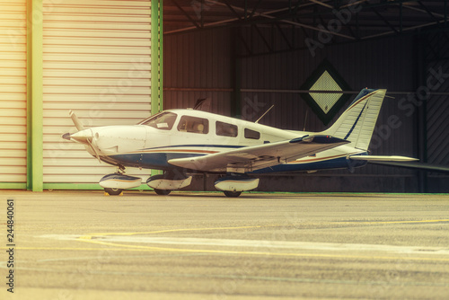 Propeller plane parking at the airport. Sunny day. In front of hangar.