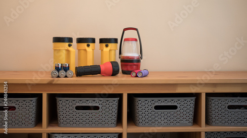 Flashlights and batteries laid out on a table prepared for a power outage.