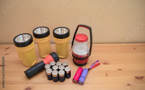 Flashlights and batteries laid out on a table prepared for a power outage.