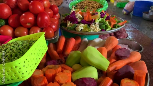 Wide variety of fresh vegetables such as carrot, chayote, tomatoes and many more on display for sale with a lady hand in the background photo