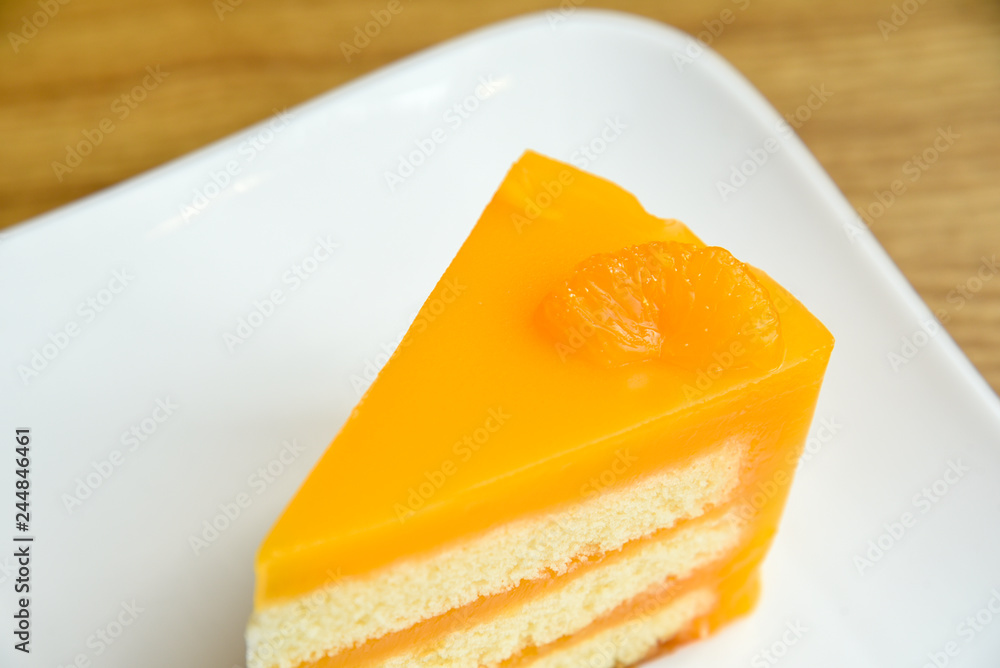 Orange cake in a white plate on wooden background , fruit cake Orange cake in a white plate on wooden background , fruit cake