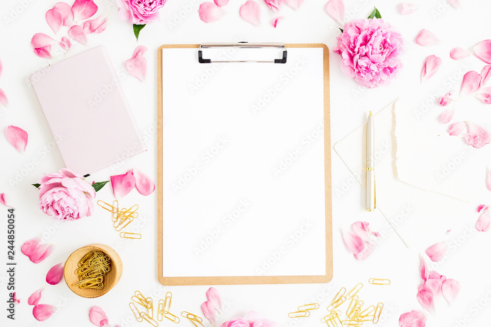 Work place with clipboard, pastel flowers and accessories on white background. Flat lay, top view. Freelancer concept Work place with clipboard, pastel flowers and accessories on white background. Flat lay, top view. Freelancer concept