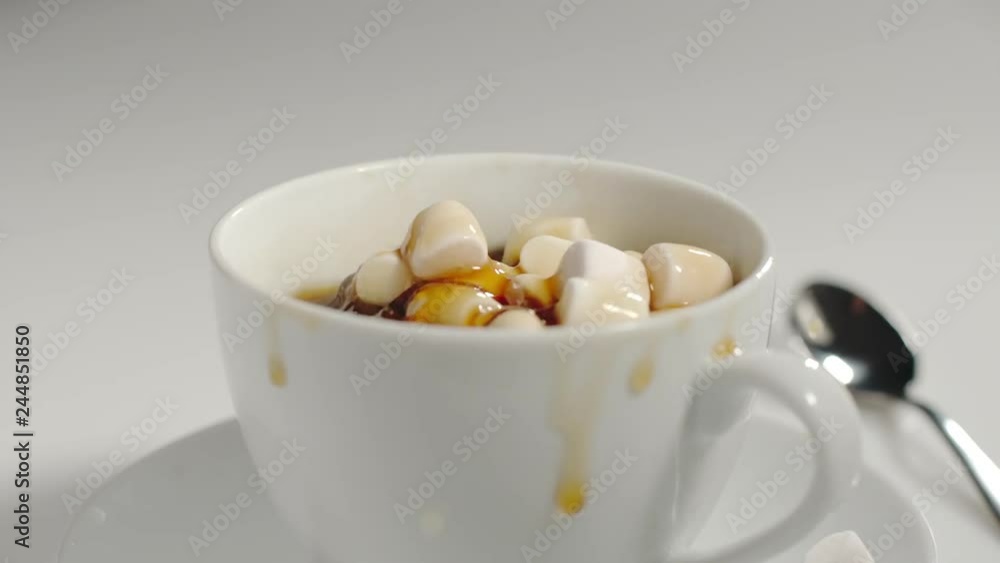 SLOW MOTION: Marshmallow falls into a cup of black coffee - Side view SLOW MOTION: Marshmallow falls into a cup of black coffee - Side view